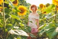 young girl enjoying nature on the field of sunflowers at sunset, portrait of the beautiful redheaded woman girl with a sunflowers Royalty Free Stock Photo