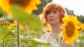 young girl enjoying nature on the field of sunflowers at sunset, portrait of the beautiful redheaded woman girl with a sunflowers Royalty Free Stock Photo