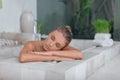 Young girl enjoys spa treatments in the bathroom with flowers Royalty Free Stock Photo