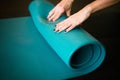 Young girl enrolling blue yoga mat after practicing workout and crossfit Royalty Free Stock Photo