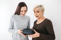 A young girl explains to an elderly woman how to use virtual reality glasses. The older generation and new technologies. Royalty Free Stock Photo