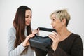 A young girl explains to an elderly woman how to use virtual reality glasses. The older generation and new technologies. Royalty Free Stock Photo