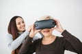 A young girl explains to an elderly woman how to use virtual reality glasses. The older generation and new technologies. Royalty Free Stock Photo