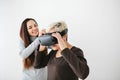 A young girl explains to an elderly woman how to use virtual reality glasses. The older generation and new technologies. Royalty Free Stock Photo