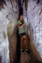 Young girl explores narrow cave Royalty Free Stock Photo