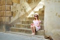 Young girl exploring in Montalcino town, located on top of a hill top and surrounded by vineyards, known worldwide for the