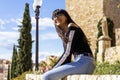 Young woman eyeglasses portrait, sitting on stoned bench, smiling happy, looking to camera Royalty Free Stock Photo