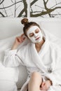 Young girl with face mask. skin care. Young beautiful girl relaxing with facial masks on over white background