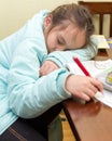 Young girl falling asleep doing homework Royalty Free Stock Photo