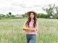 Young girl farmer in the field.famele farmer in a straw hat, plaid shirt and jeans in the garden Royalty Free Stock Photo
