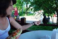 A young girl feeds pigeons bread sitting on the summer veranda in a cafe