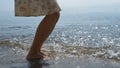 Young girl feet jumping on sea waves close up. Slim woman splashing ocean water.