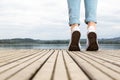 Young girl feet with shoes and blue jeans on a wooden pier tiptoed Royalty Free Stock Photo