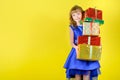 Young girl in a festive blue dress holding a lot of gifts Royalty Free Stock Photo