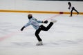 Young girl figure skater on the ice arena in motion.
