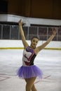 Young girl a figure skater in purple dress on an ice arena Royalty Free Stock Photo