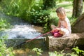 Young Girl Fishing On Bank Of Stream With Net