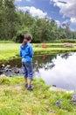 Young girl fishing on pond during bright summer day Royalty Free Stock Photo