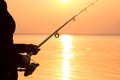 Young girl fishing at sunset near the sea Royalty Free Stock Photo