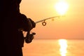 Young girl fishing at sunset near the sea Royalty Free Stock Photo