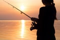 Young girl fishing at sunset near the sea Royalty Free Stock Photo