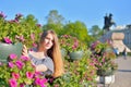 A young girl at the flower beds on the background of the monument bronze Horseman in Saint-Petersburg