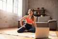 Young girl follows with a laptop a gym exercises. She is at home due to coronavirus codiv-19 quarantine