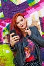 Young girl in front of graffiti making selfie