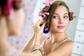 Young girl front the mirror puts earring Royalty Free Stock Photo