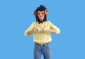 Studio shot of young woman in funny monkey mask showing thumbs up with both hands