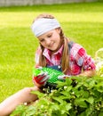 Young girl in the garden caring for strawberries Royalty Free Stock Photo