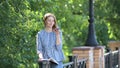 Young girl in the garden talking on the phone and making notes in her notebook.