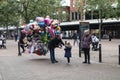 Young girl gets a fancy baloon from a street vendor in high street setting