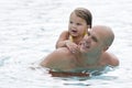 Young girl getting piggyback ride from dad in pool Royalty Free Stock Photo