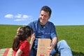 Young girl gives her father flower and a card