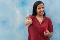 Young girl giving a thumbs up as a sign of success. Portrait of a happy and smiling woman Royalty Free Stock Photo