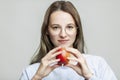 A young girl in glasses lives a red apple in her hands. Healthy eating and vegetarianism Royalty Free Stock Photo