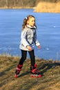 Young girl goes in roller skates on the ground