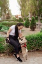 Young girl goes for walk with doggy pug in park. Selective focus