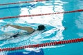 Young girl in goggles and cap swimming crawl stroke style in the blue water pool. Royalty Free Stock Photo