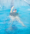 Young girl in goggles swimming back crawl stroke style Royalty Free Stock Photo