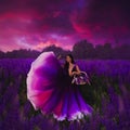 A young girl in a gradient haute couture dress standing in a blooming lupine field Royalty Free Stock Photo