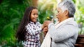 Young girl, grandmother and a surprise flower for senior woman or excited child or family bond with pensioner and giving Royalty Free Stock Photo