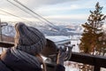 A young girl in a gray knitted hat looks through stationary binoculars on an observation deck in the alatai mountains in winter Royalty Free Stock Photo