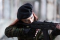 A young girl with a green camouflage uniform and a black beret with a gun among the ruins. Girl warrior with weapons Royalty Free Stock Photo