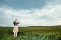 Young girl in a green field. Stylish girl. Green grass and blue sky. Emotional woman. plener. Travel. trip.