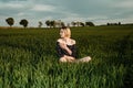 Young girl in a green field. Stylish girl. Green grass and blue sky. Emotional woman. plener. Travel. trip.