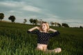 Young girl in a green field. Stylish girl. Green grass and blue sky. Emotional woman. plener. Travel. trip.