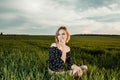 Young girl in a green field. Stylish girl. Green grass and blue sky. Emotional woman. plener. Travel. trip.