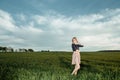 Young girl in a green field. Stylish girl. Green grass and blue sky. Emotional woman. plener. Travel. trip.